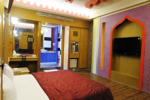 a bedroom with a bed and a flat screen tv at 富晴汽車旅館Fu Ching Motel in Changhua City