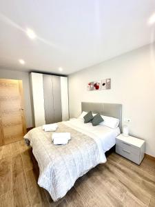 a bedroom with two beds with white sheets at Apartamento La Muralla 2B in Aguilar de Campóo
