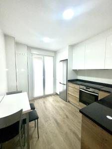 a kitchen with white cabinets and a white table and a table sidx sidx at Apartamento La Muralla 2B in Aguilar de Campóo