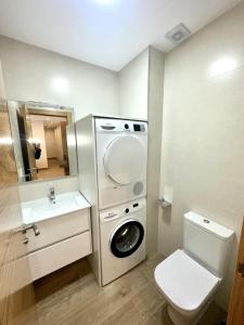 a bathroom with a washing machine and a toilet at Apartamento La Muralla 2B in Aguilar de Campóo