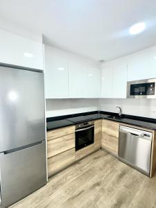 a kitchen with white cabinets and stainless steel appliances at Apartamento La Muralla 2B in Aguilar de Campóo