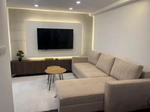 a living room with a couch and a flat screen tv at Apartman Kvesić in Široki Brijeg