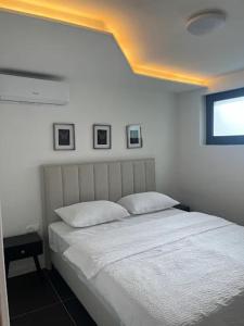 a bedroom with a white bed with two pillows at Apartman Kvesić in Široki Brijeg