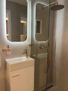 a bathroom with a sink and a shower with a mirror at Apartman Kvesić in Široki Brijeg