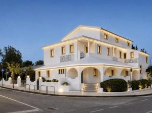 a large white building on the side of a street at Hotel Cala d'Oro - Hotel a pochi minuti dal mare di Cala Liberotto in Cala Liberotto