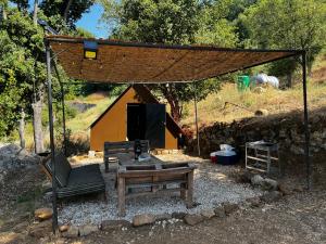 a picnic shelter with a table and a bench and a picnic table at Kroom cabins in Bâne