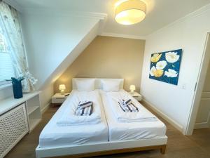 a bedroom with a white bed with two pillows at Syltstyle 12 in Tinnum