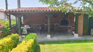 a pavilion with a table and a fireplace in a yard at Posada Herrán in Santillana del Mar