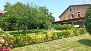 a garden in front of a building with flowers at Posada Herrán in Santillana del Mar