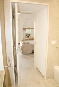 a bathroom with a bedroom with a bed and a mirror at Antica Stella in Specchia +20 photos