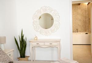 a mirror on a wall above a white dressing table at Antica Stella in Specchia