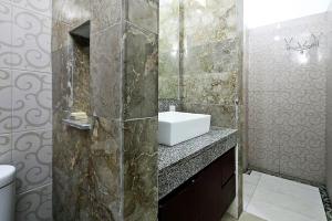 a bathroom with a sink and a toilet in it at Indah Homestay in Seminyak