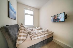a living room with a couch and a television on the wall at Villa Sofia in Borkum