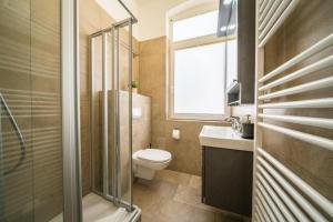 a bathroom with a toilet and a sink and a window at Villa Sofia in Borkum
