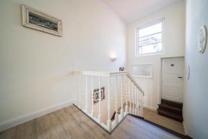 a white staircase in a white room with a window at Villa Sofia in Borkum
