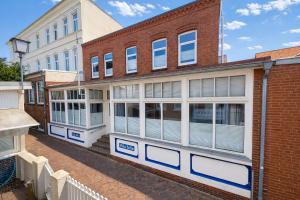 a brick building with white windows on a street at Villa Sofia in Borkum