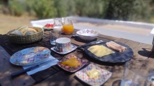 a wooden table topped with plates of food and orange juice at Alegria rustica 2 in Mação