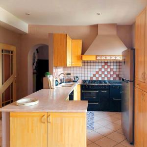a kitchen with wooden cabinets and a black refrigerator at Casa ai Tre Colli, Tres in Tres
