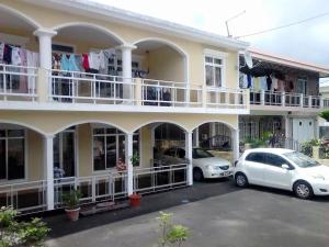 two cars parked in a parking lot in front of a building at Shivram guest house in Plaine Magnien