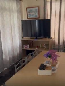 a table with a tv and a vase of flowers on it at Shivram guest house in Plaine Magnien