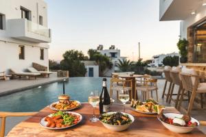 a table with plates of food and a bottle of wine at Axopetra Boutique Hotel in Agiassos
