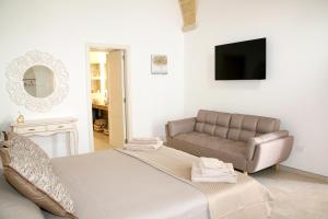 a living room with a bed and a couch at Antica Stella in Specchia