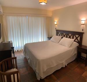 a bedroom with a large white bed and a window at Petit Chateau Hotel Boutique in Punta del Este +36 photos