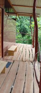 a wooden bench sitting on a wooden deck at The Forest Cabin in Parrita