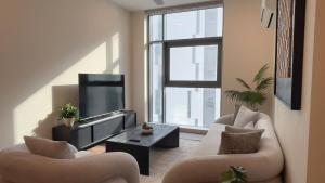 a living room with two couches and a tv at Premium 2BHK Modern Design in Muscat