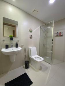 a bathroom with a toilet and a sink and a shower at Premium 2BHK Modern Design in Muscat +10 photos