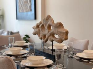 a dining table with plates and bowls on it at Premium 2BHK Modern Design in Muscat