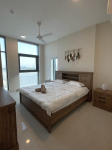 a bedroom with a large bed in a room with windows at Premium 2BHK Modern Design in Muscat