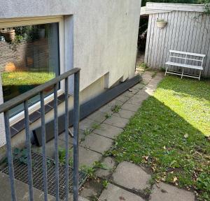 a fence in front of a house with a bench at Genbrugsfabrikkens Tiny apartment in Holbæk