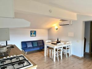 eine Küche und ein Wohnzimmer mit Tisch und Stühlen in der Unterkunft Ferula romantica mansarda tra fiumi e montagne Sardegna in Seùlo
