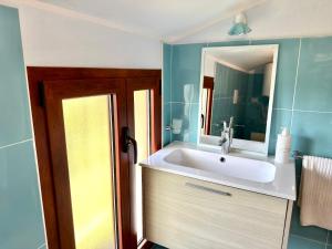 ein Badezimmer mit Waschbecken und Spiegel in der Unterkunft Ferula romantica mansarda tra fiumi e montagne Sardegna in Seùlo