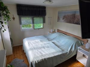 a bedroom with a bed and two windows at Smaland Trollsjö in Mönsterås