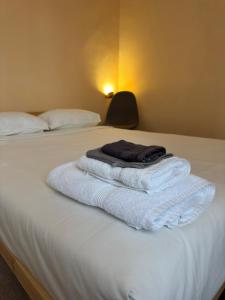 a pile of towels sitting on top of a bed at Miquinhas Norte in Freamunde