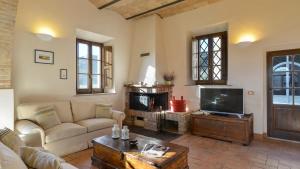 a living room with a couch and a tv at ALBORATA 10, Emma Villas in San Giovanni dʼAsso