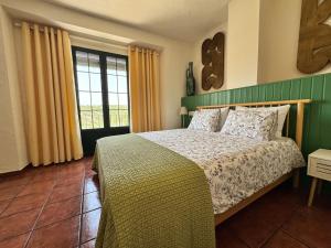 a bedroom with a bed and a large window at Cortijo Cenascuras in Priego de Córdoba