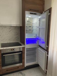 an empty refrigerator with its door open in a kitchen at Mājīgie Apartamenti Saldū in Saldus