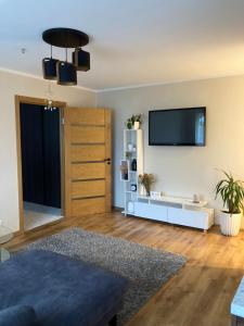 a living room with a flat screen tv on a wall at Mājīgie Apartamenti Saldū in Saldus