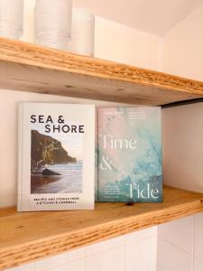 two books sitting on a shelf at The Coastal Cosy, St Merryn, Padstow in Saint Merryn