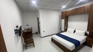 a bedroom with a bed and a desk in it at Grand Stay Hotel in Seeduwa +3 photos