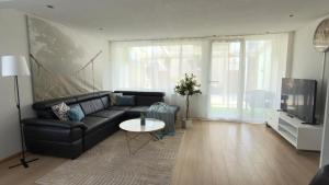 a living room with a black couch and a tv at Basel Haven in Münchenstein