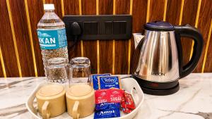 a counter top with a coffee maker and some food at Hotel Asha Palace By Basotel in Deoghar