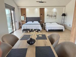 a room with two beds and a table and chairs at Apartments Lj in Ulcinj