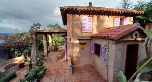 a small brick building with a tile roof at Cabaña Las Lavandas in Samaipata