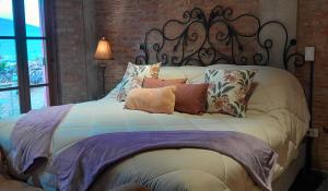 a bed with pillows on it in a bedroom at Cabaña Las Lavandas in Samaipata