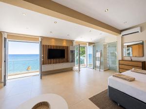 a bedroom with a bed and a television and the ocean at Infinity Beach House by KLV in Argostoli