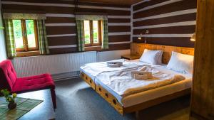 a bedroom with a large bed and a red chair at Pension Skalicky in Pec pod Sněžkou